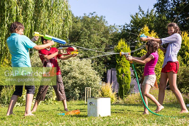 Children having a water fight in the garden