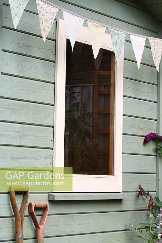 Step by step of making garden bunting - The finished bunting hanging on a painted summerhouse