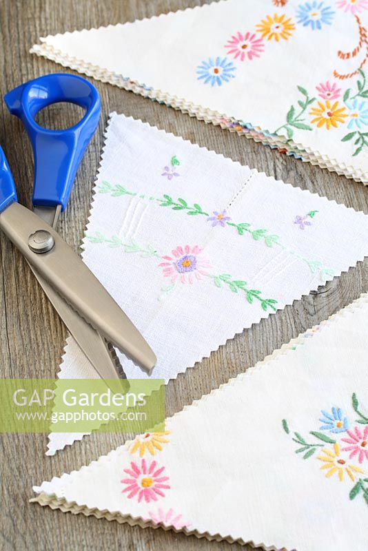 Step by step of making garden bunting with vintage linens and buttons - Using pinking shears, cut out your triangles