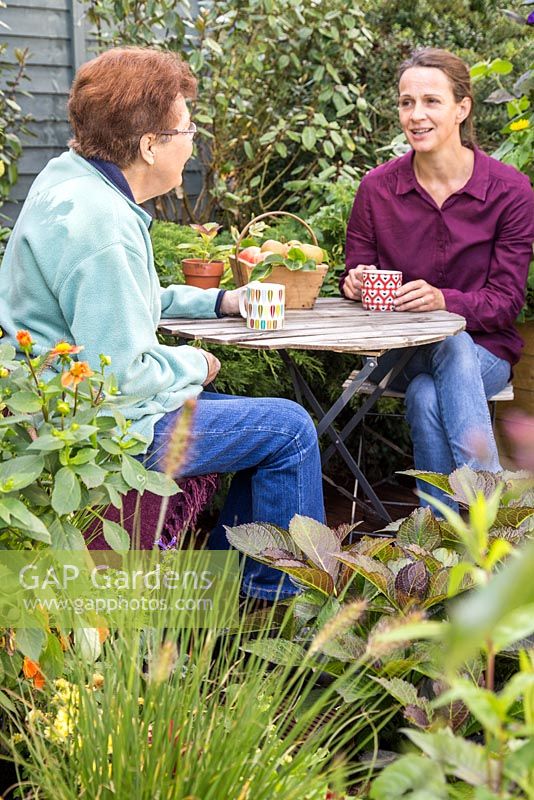 Mixed generations drinking tea in a small urban garden
