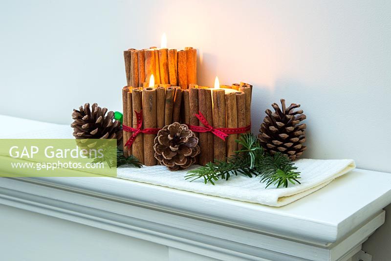 Christmas candle decorations made using cinnamon sticks and ribbon