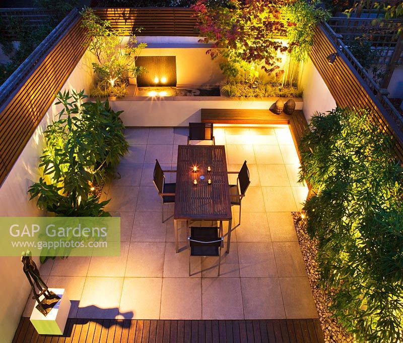 Overview of modern minimalist garden lit up at night 