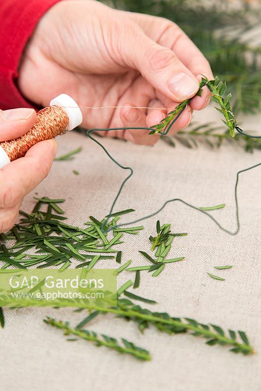 Attaching Christmas tree cuttings with thread.