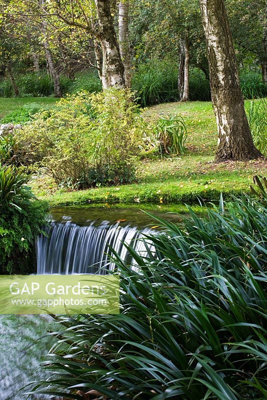 Ninfa garden, Giardini di Ninfa, Italy. Stream with natural water fall