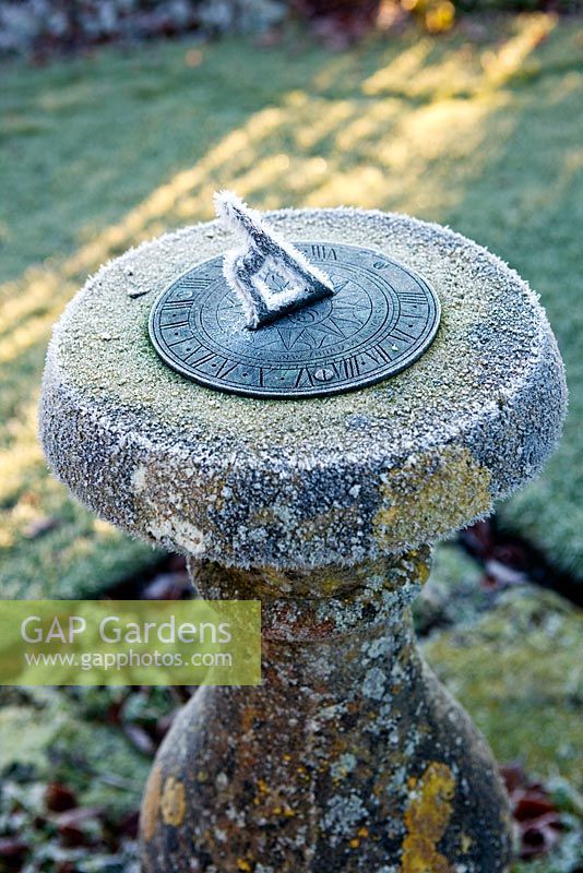 Frosted stone sundial at dawn. Wollerton Old Hall, Shropshire