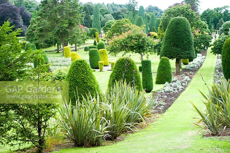 Looking over the immense formal garden studded with shaped colourful trees and topiary immaculately pruned 
