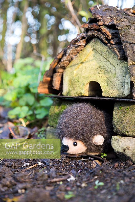 Cuddly Hedgehog toy sat in the entrance of a homemade hedgehog house