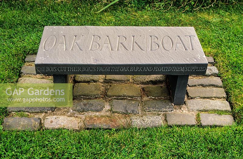 Seat engraved with words Oak Bark Boat. Little Sparta, Dunsyre, Lanark, Lanarkshire. Scotland. 