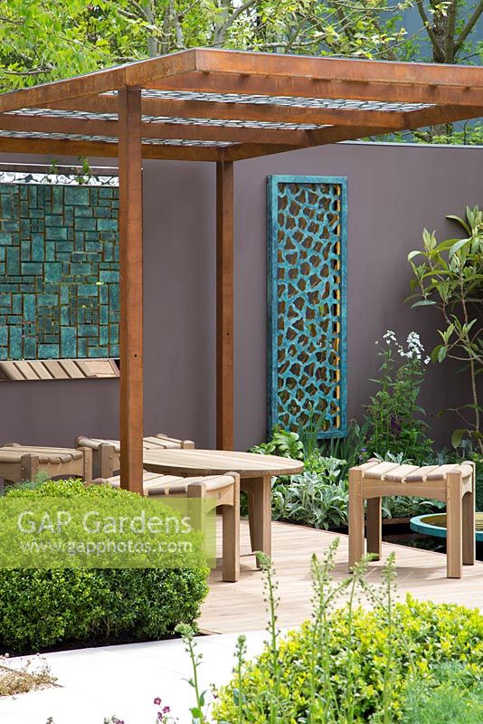 Garden seating area with sculptures by David Harber. Corten steel pergola.