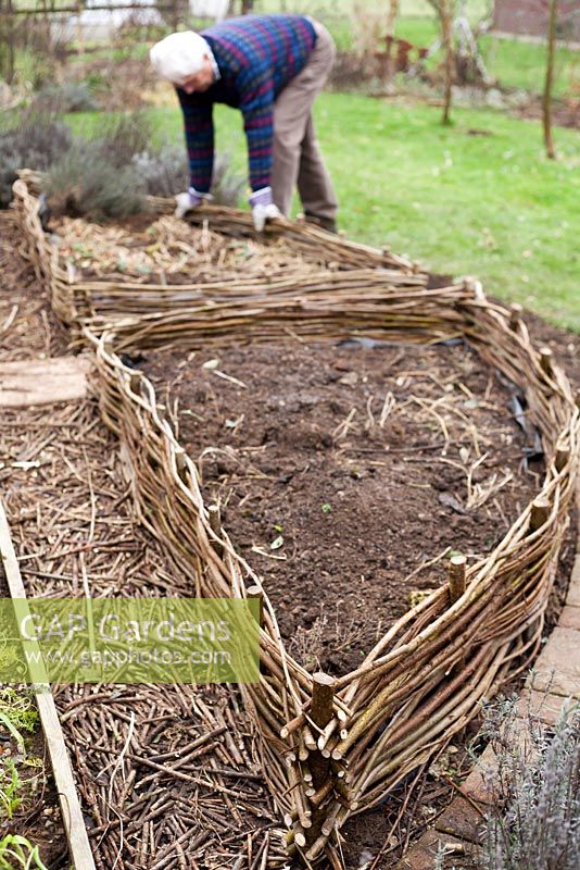 Making a hazel fence of a raised vegetable bed