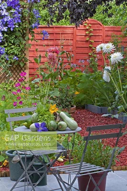 Flowery vegetable garden with courgettes on a table