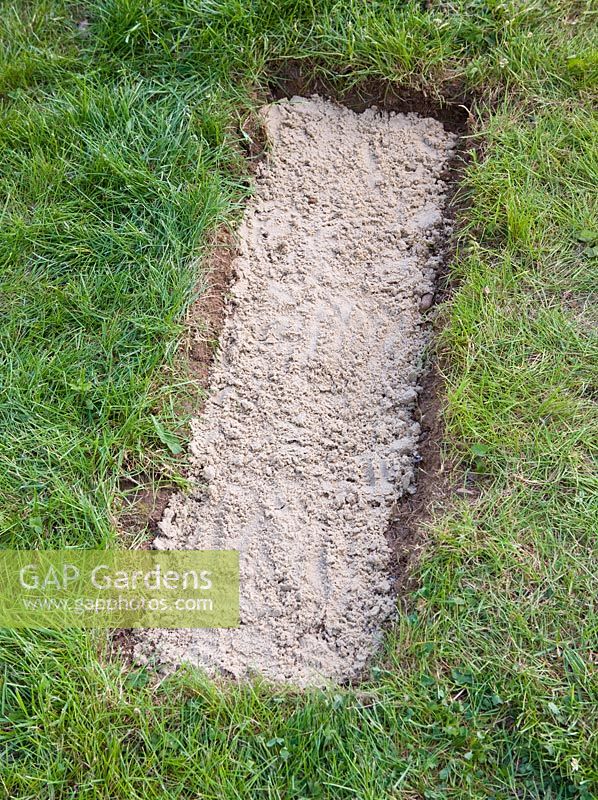 Cement in hole in lawn for wooden board used as a stepping stone