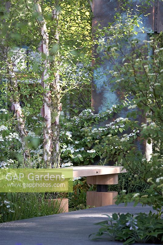 Patinated copper archway with wooden seating and Betula nigra and Tellima grandiflora. RHS Chelsea Flower Show 2014 - The Brewin Dolphin Garden, awarded silver gilt