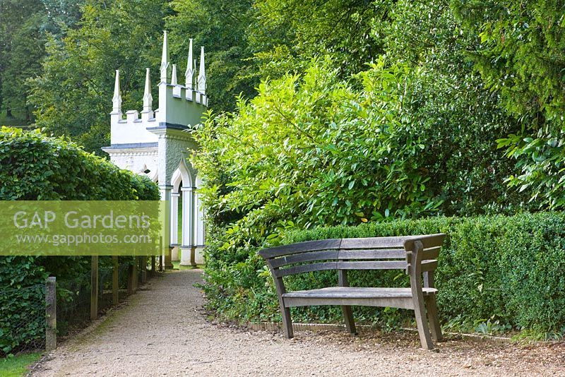 Wooden bench with the exedra in the background. Painswick Rococo Garden, Gloucestershire 