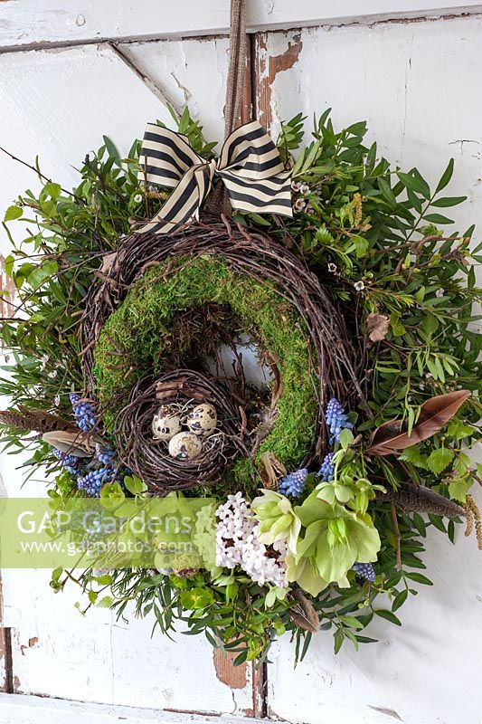 Easter wreath with nest of eggs and spring flowers - blossom, muscari and hellebores