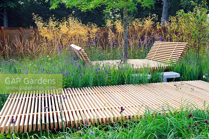 Extensive planting along Timber walkway and timber resting area. Grasses along metal fence. Description: The Sky is The Limit. Design: Sam Ovens 