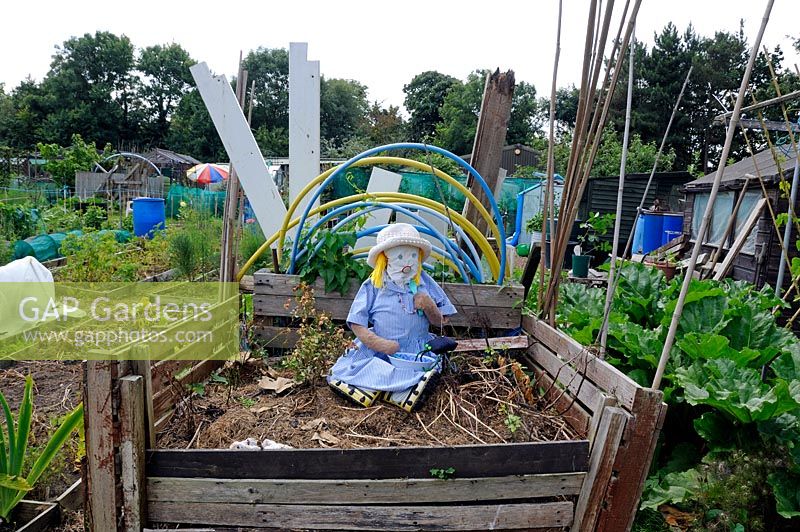 Little Miss Muffet girl scarecrow sitting in compost, Paddock Allotments 