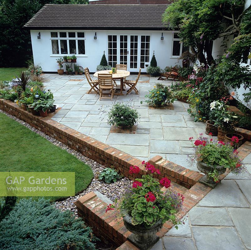 After makeover - It takes three months to transform the old terrace, quadrupling its size and planting in beds beside the house to soften its angles.