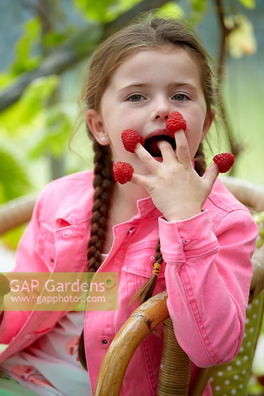 Girl eating raspberries