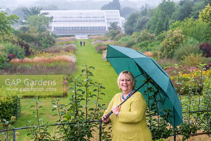 Sue Biggs, director general of the Royal Horticultural Society. Pictured at RHS Wisley in heavy rain, standing on The Mount, looking down the Piet Oudolf borders towards the glasshouse at the bottom of the hill.
