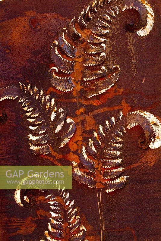 Ornate rusty metal panel with fern leaf providing focal point. At Domaine de Cambou, Verfeil, Haute-Garonne, Midi Pyranees, France.