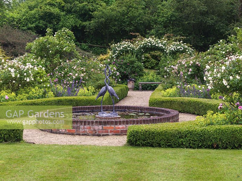 Rose Garden. Central lily pond with sculpture. Box-edged beds of roses - Comte de Chambord, Prosperity, andersonii, Felicia and City of York on moongate