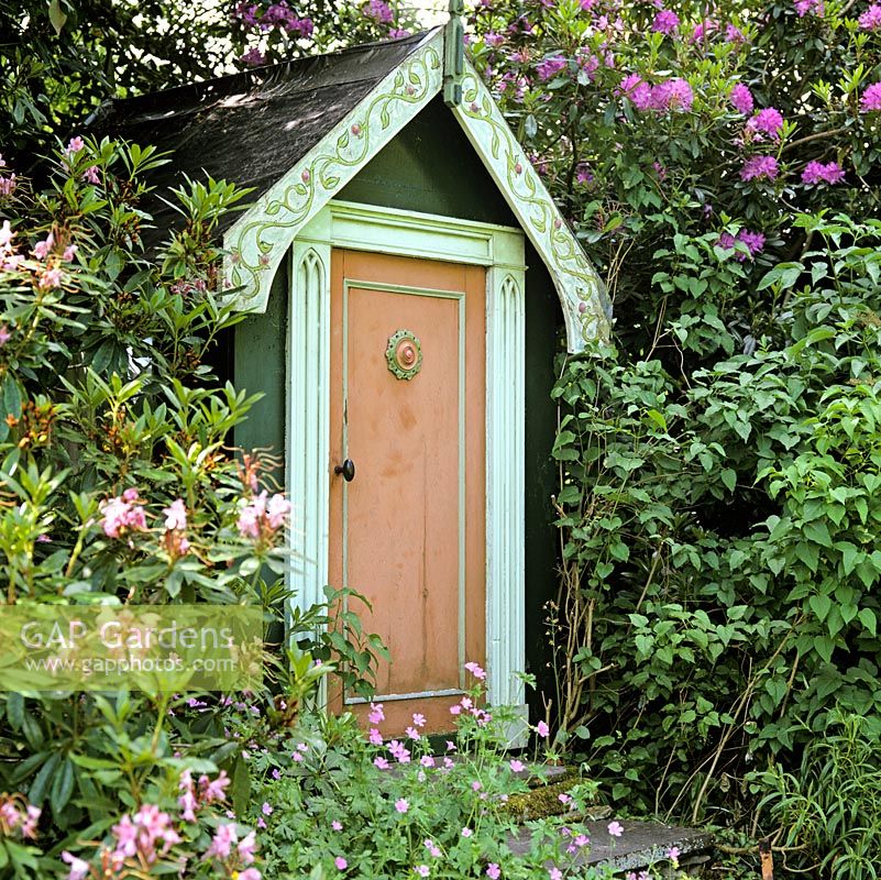 Tucked away in shade of rhododendron, a childrens playhouse.