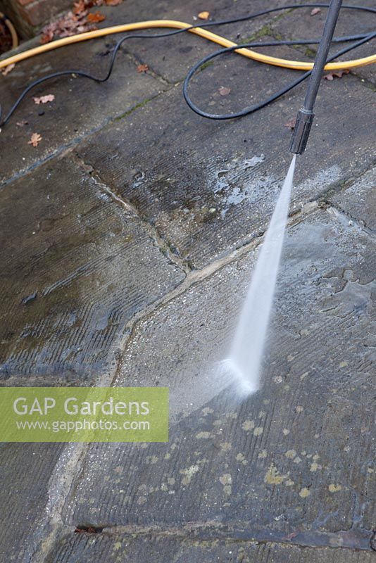 Using a Karcher high pressure jet spray to clean a patio surface, close up of lance