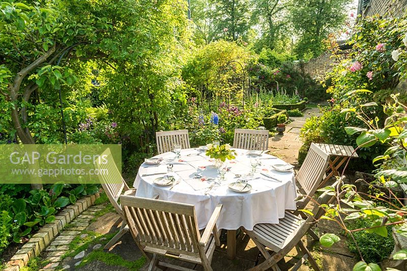 Secluded town garden in Cambridge with table laid ready for supper