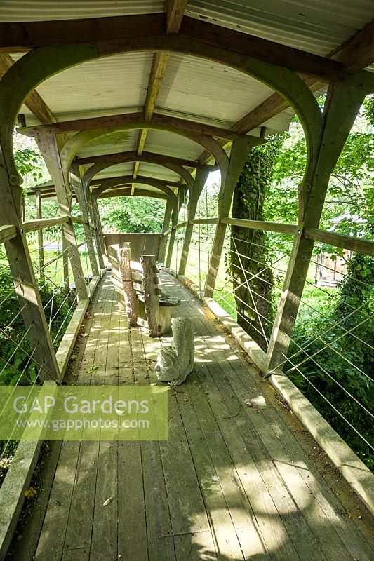 The Cloister Bridge, built 2004-2005, crosses a sunken track to connect the garden with a lower field. A trussed girder bridge made using oak, larch, sweet chestnut and stainless steel wire, designed and built by Mathew Robinson and assistants. Caervallack Farm, St Martin, Helston, Cornwall, UK