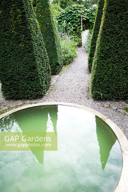The Well Garden with central reflecting pool and tall yew spires. Wollerton Old Hall, nr Market Drayton, Shropshire, UK