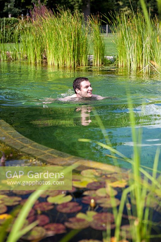 Man swimming in a swimming pond. September.