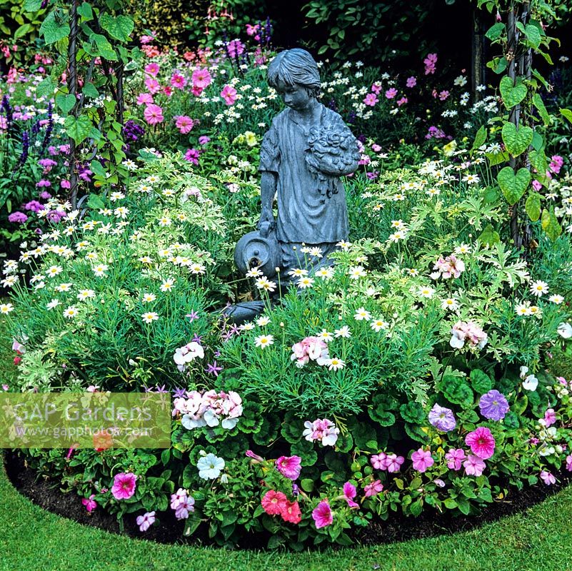 Girl water feature below arch of morning glory, in bed of marguerite, busy-lizzies, pelargonium, geranium, isotoma and petunia.