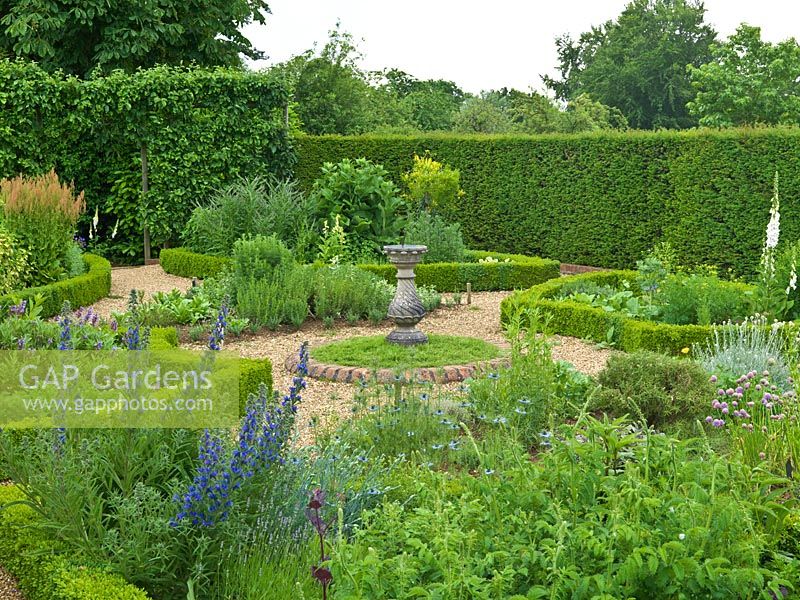 Herb Garden. Hedges planted with yew, box, teucrium, origanum. Beds: lavender, fennel, catmint, rosemary, salvia, chives, foxglove, echium, nigella, rue, feverfew. Sundial in chamomile circle.