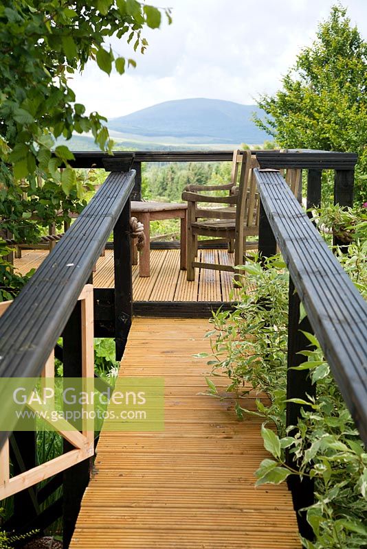Seating area on elevated decking platform with view of hills