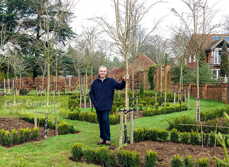 Mark Porter in the newly laid out potager, planted with apple and pear trees, but awaiting fruit and vegetables. Semi-circular layout with radial paths.