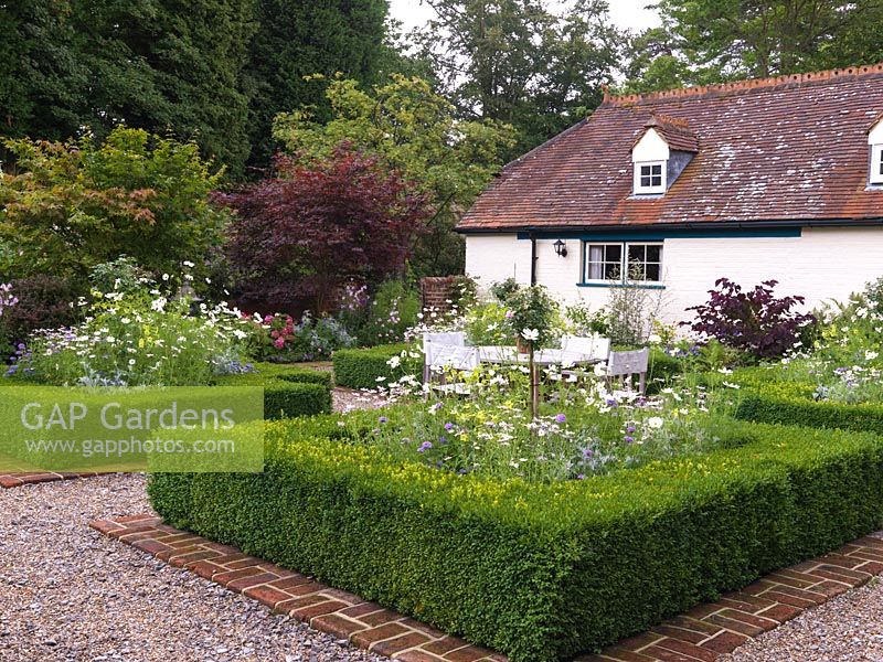 Walled cottage garden with parterre of 4 square beds filled with roses, Cosmos Sonata White, mauve verbena, anthemis, Nicotiana Lime Green, Senecio viravira.