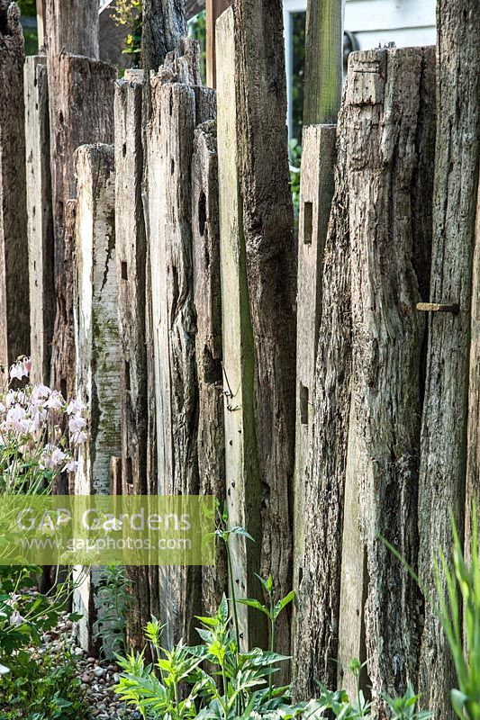Fence made of reclaimed timber and driftwood in the nursery. King John's Nursery, Etchingham, East Sussex, UK