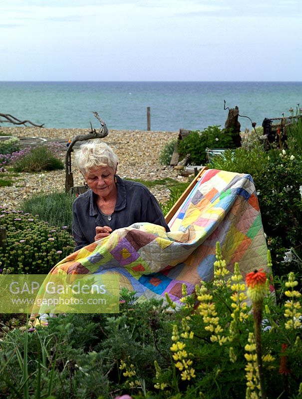 Liz Shackleton, textile artist, works in her seaside garden on a patchwork quilt.