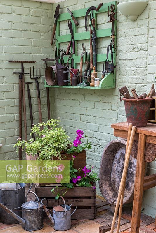 A conservatory with a selection of vintage gardening tools and gardening paraphernalia.