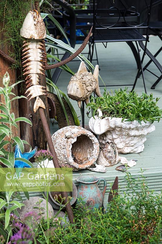 Salvaged seaside inspired decorations on the edge of a deck.