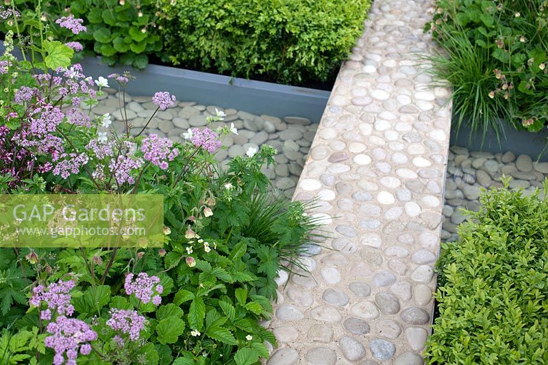 Chesterton Humbers 'A Game of Contrast', Malvern Spring Gardening Show 2014, offers a study of the relationship between man and the natural world, with pebble and concrete path crossing rill with pebbles - Designer: Lorenzo Soprani Volpini - LSV Gardens and Associates