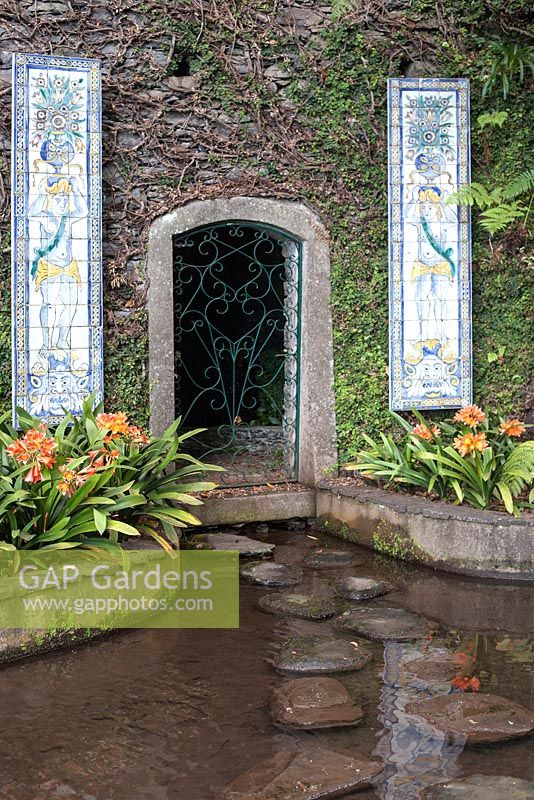 Tiled panels and doorway into the bank at Monte Palace Tropical Garden, Madeira, with clivia miniata fringing the pond