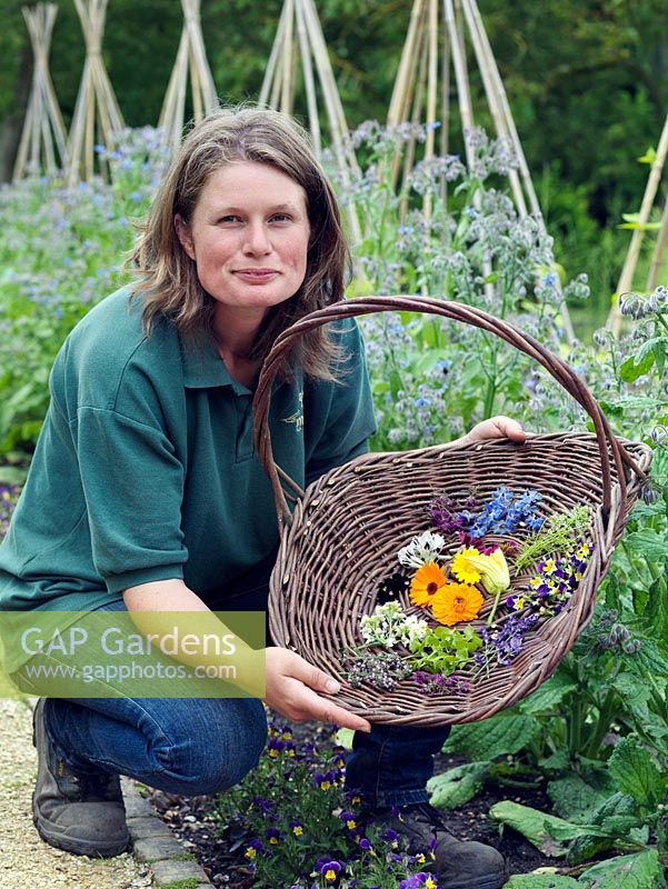 Jo Campbell with a basket of freshly picked edible flowers to include borage, marigold, courgette, thyme, lavender, borage, bean and viola.