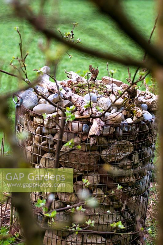 Basket of stones as home or refuge for small creatures, topped with sempervivum