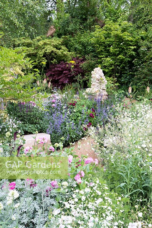 Purbeck stone sculputure through cottage style planting - The M and G Garden 2015 - The Retreat, RHS Chelsea Flower Show 2015 