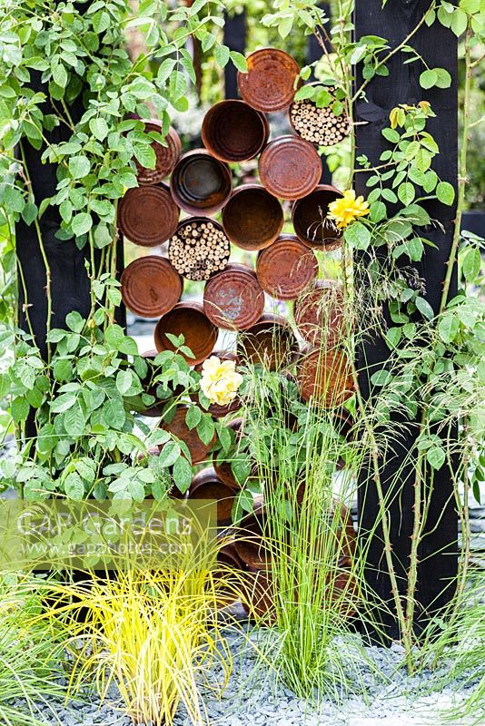 The Great Chelsea Garden Challenge Garden. Detail of rusted tin cans for insect homes. RHS Chelsea Flower Show, 2015