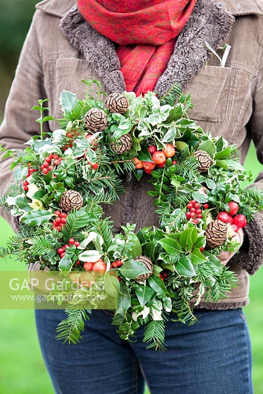 Lady holding a Christmas wreath. December.
