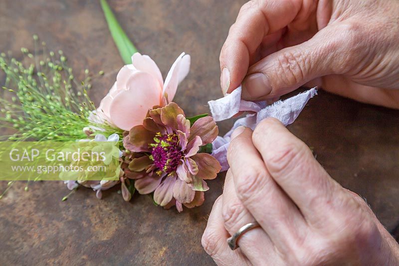 Attaching silk to the Buttonhole for an aesthetic touch. Zinnia elegans 'Queen Red Lime', Rosa 'Ambridge Rose', Panicum elegans 'Frosted Explosion' and Abelia x grandiflora