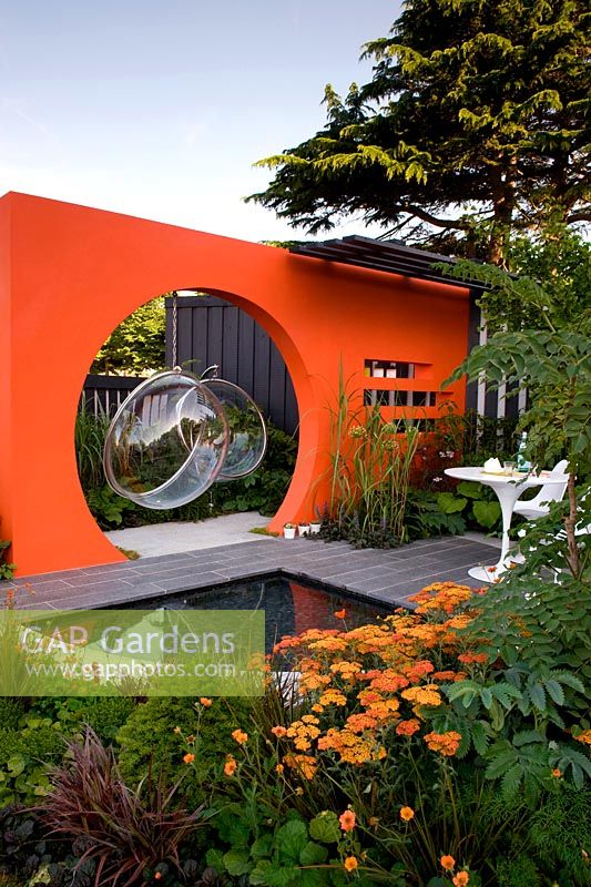 Creations Mid Century Modern - Best Low Cost High Impact Garden. RHS Hampton Court 2013. Orange moongate wall divider with pool. Design: Adele Ford and Susan Willmott Sponsor: Outdoor Creations